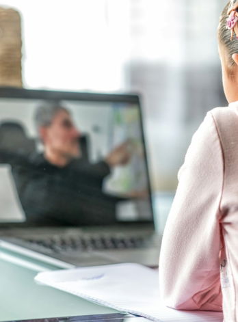 woman in pink long sleeve shirt sitting in front of macbook pro